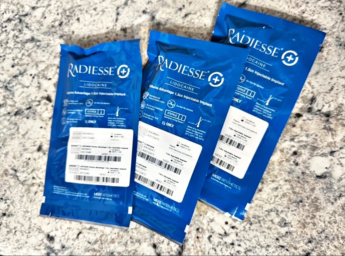 Three sealed blue pouches of Radiesse (+) Lidocaine, each labeled Volume Advantage 1.5cc Injectable Implant by Merz Aesthetics, lying on a granite counter