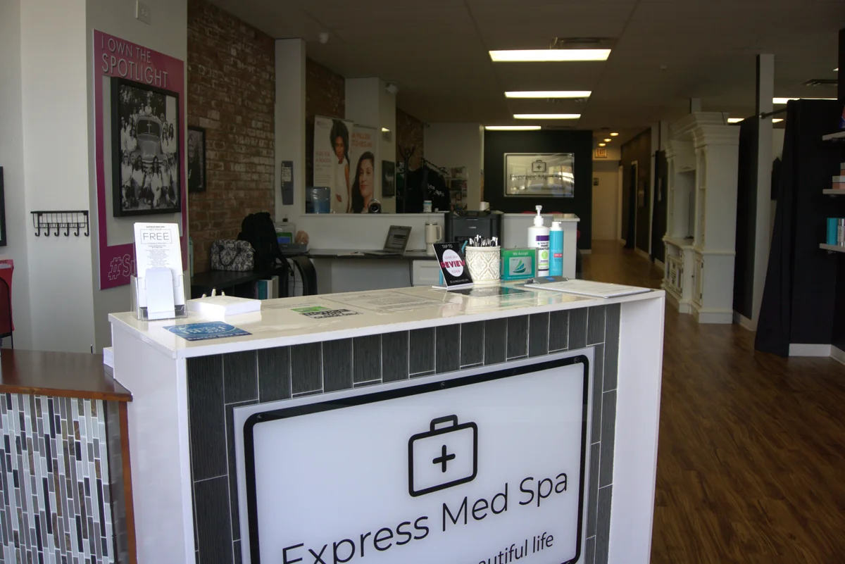 Front desk reception area of an accredited medical spa clinic with comfortable consultation seating.