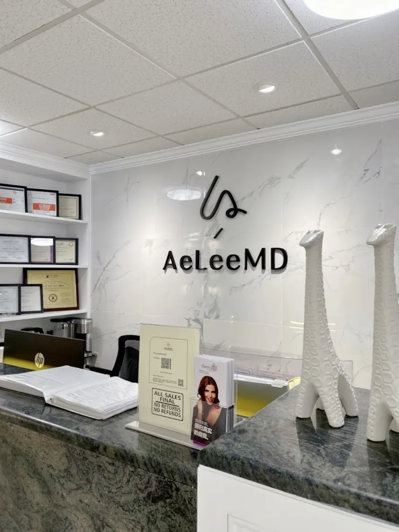 Reception counter with green granite top beneath black AeLeeMD lettering on a marble wall