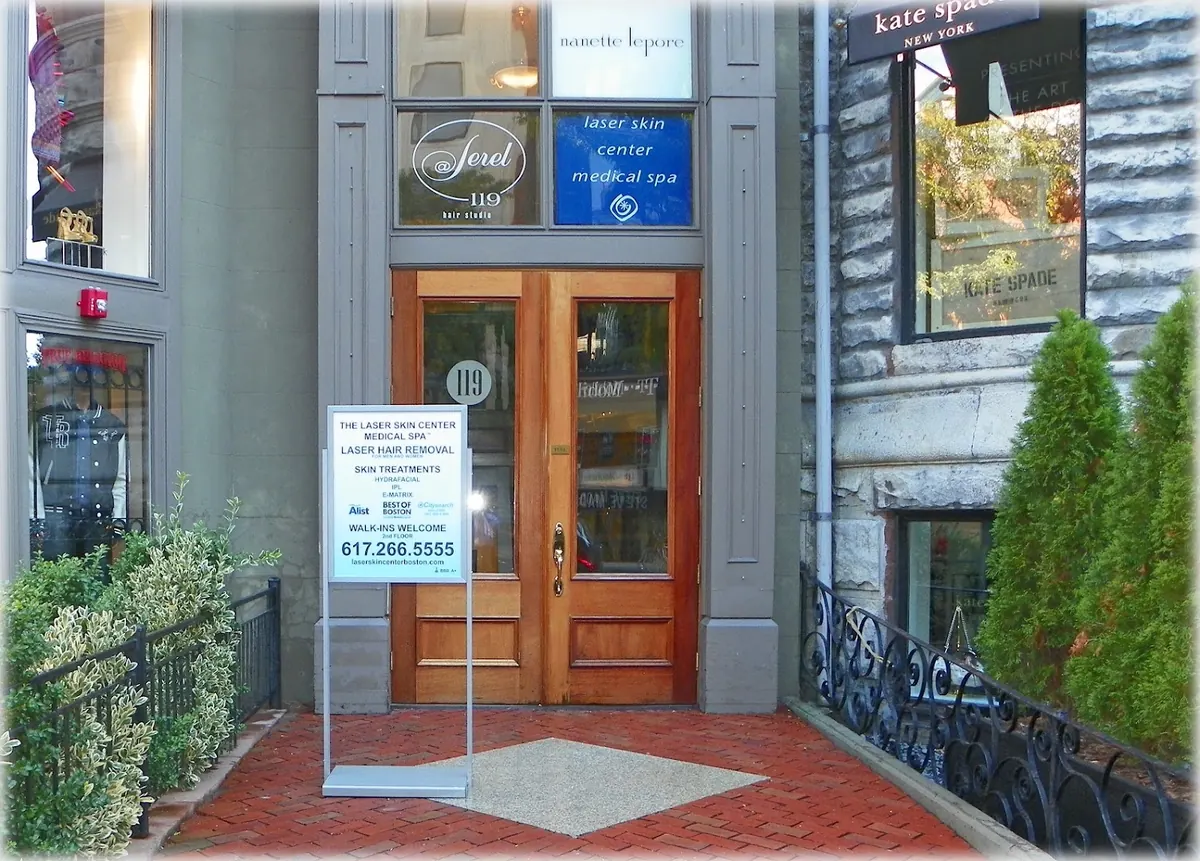 Wooden double doors numbered 119 under a Laser Skin Center Medical Spa window sign