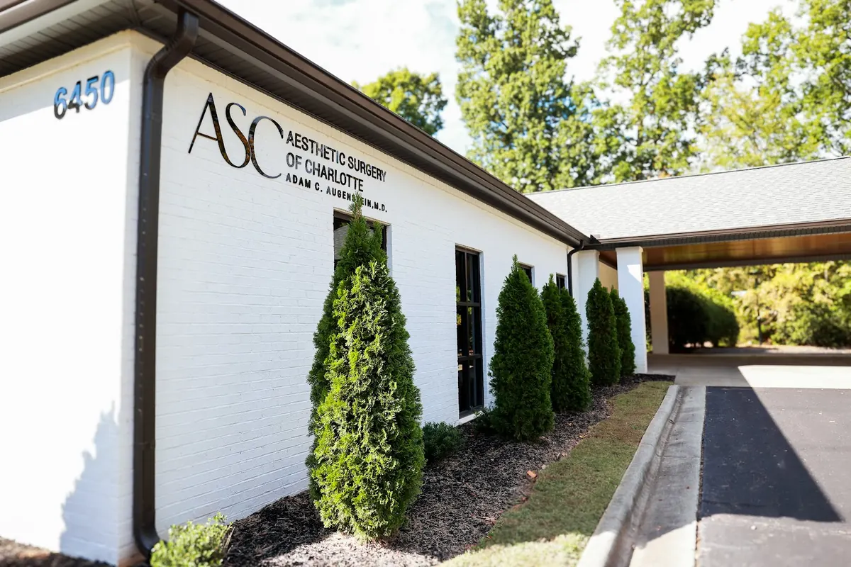 White brick building with black ASC Aesthetic Surgery of Charlotte lettering and house number 6450