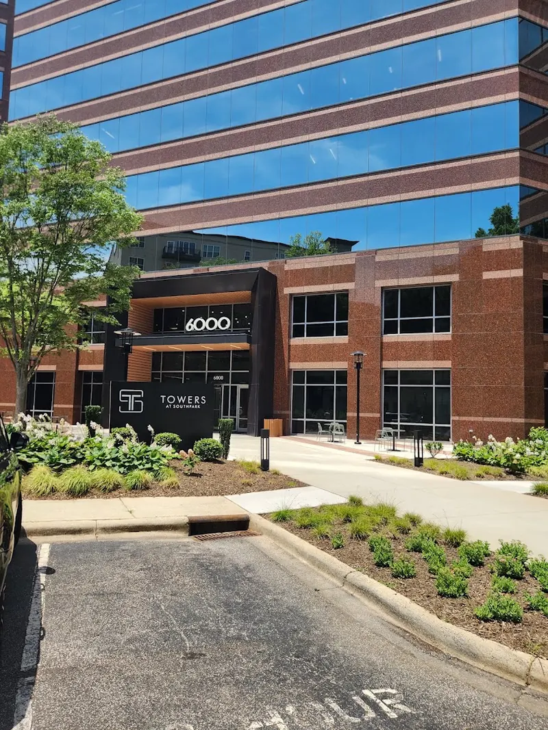 Brick and glass office building with 6000 above the entrance and a Towers at SouthPark sign