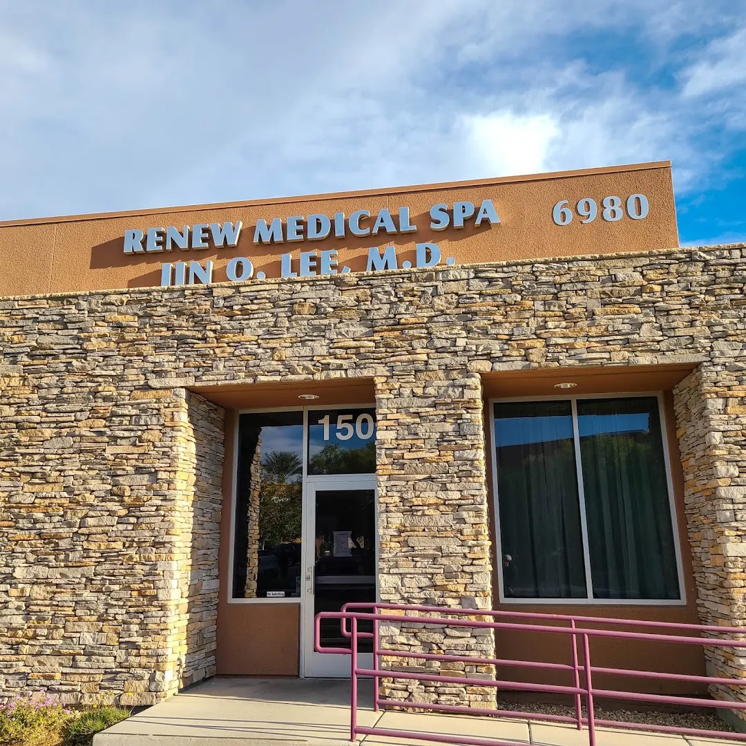 Stone-clad Renew Medical Spa building with 6980 sign, suite 150 door and pink handrail