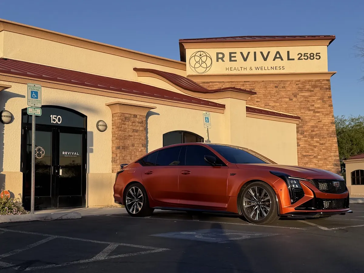 Revival Health & Wellness building with 2585 sign, suite 150 door and an orange sedan