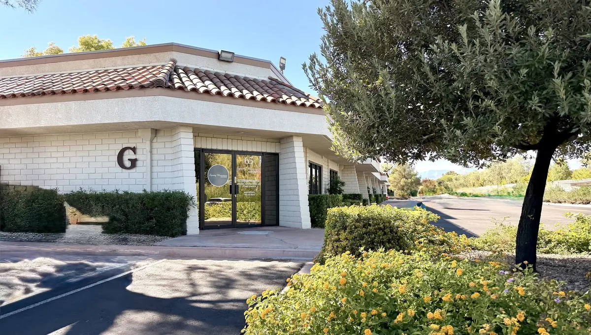 Tile-roofed building G with a Spring Mountain Aesthetics door marked 65 behind shrubs