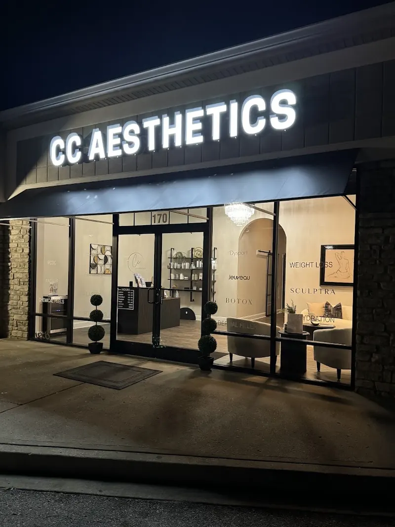 Lit CC Aesthetics sign above a glass storefront with suite number 170 at night