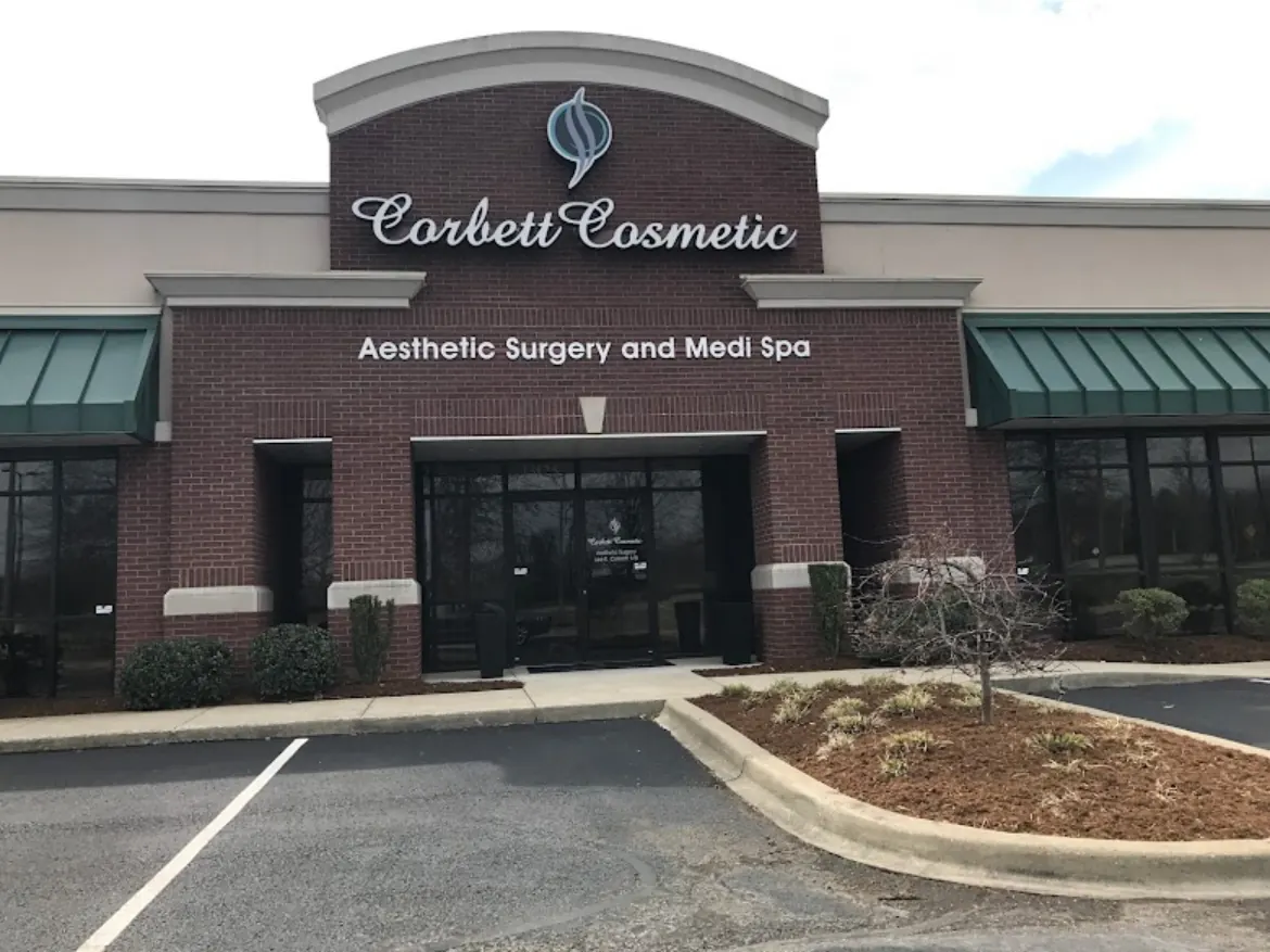 Brick storefront with Corbett Cosmetic sign above green awnings and glass entrance