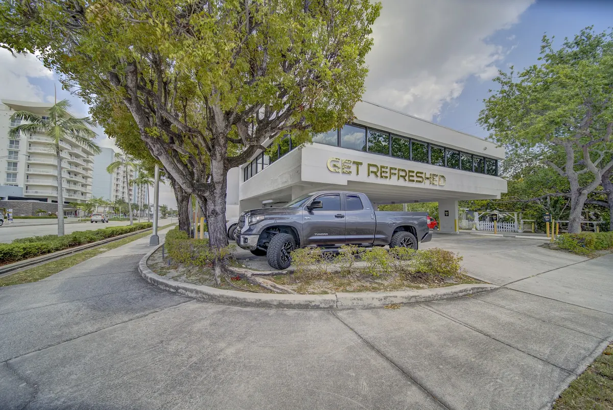 White building with gold Get Refreshed lettering above a carport and a parked pickup truck