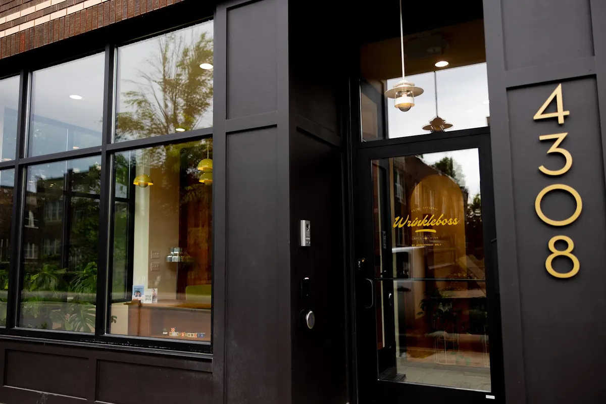 Black storefront entrance with gold 4308 numerals and Wrinkleboss lettering on the glass door