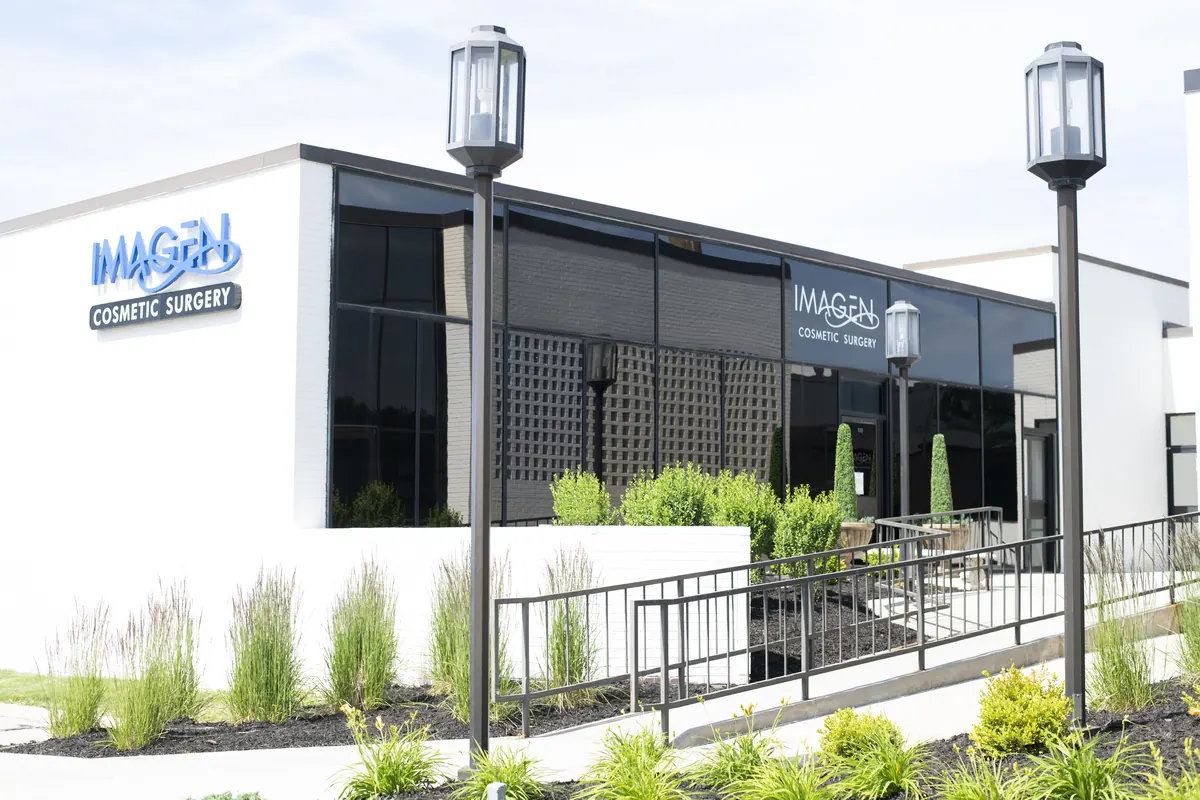 Modern white and dark building with Imagen Cosmetic Surgery signs and lamp posts