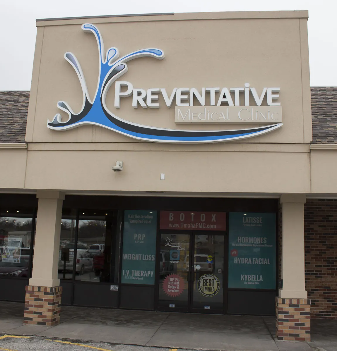 Storefront with a large Preventative Medical Clinic sign above glass doors and window decals