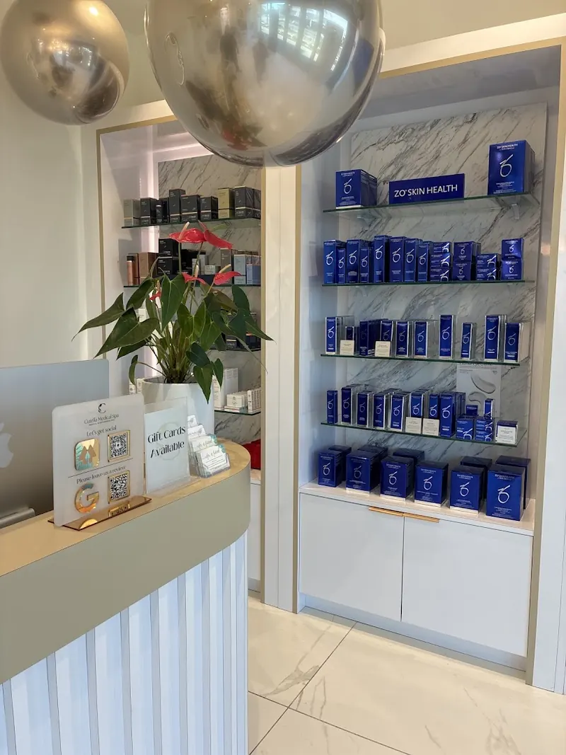 Curved reception desk with a Cutella Medical Spa sign beside shelves of skincare products