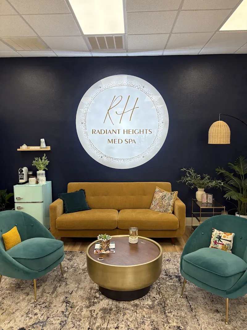Lounge with a gold sofa and green chairs beneath a lit Radiant Heights Med Spa wall sign