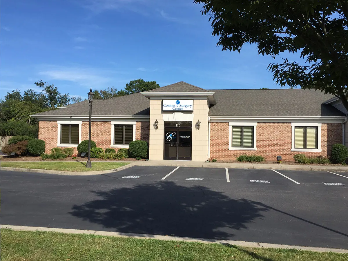 Brick office building with a Cosmetic Surgery Center sign above a door numbered 110