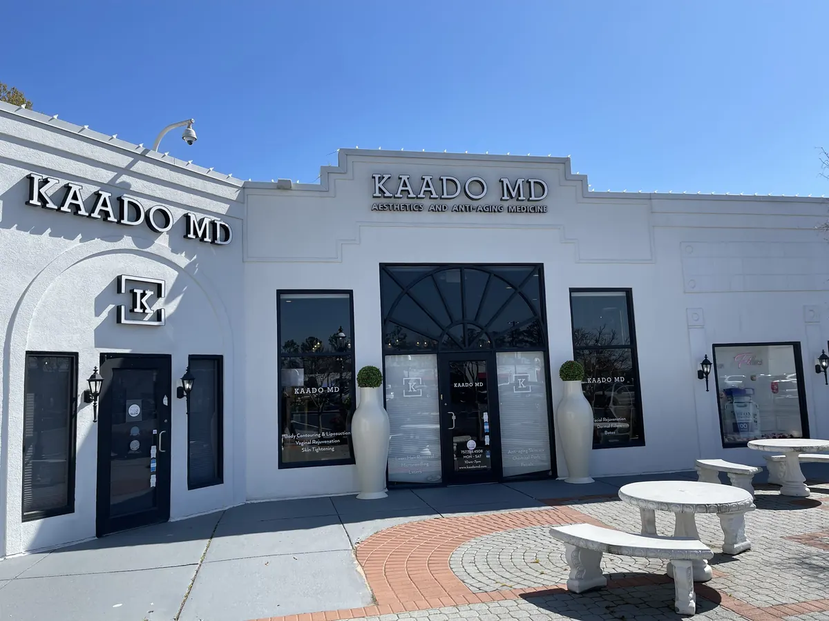 White building with KAADO MD lettering above the glass entrance and stone benches in front
